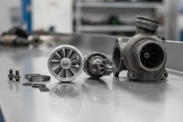 Turbina do Iveco Daily desmontada sobre bancada de oficina automotiva com peças do conjunto rotativo ao lado
